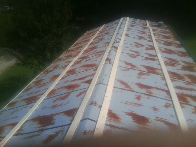 Rusted metal roof panels with new wood purlins before replacement — Storm Damage Roof Repair in Flint Hill by Roofing Brothers