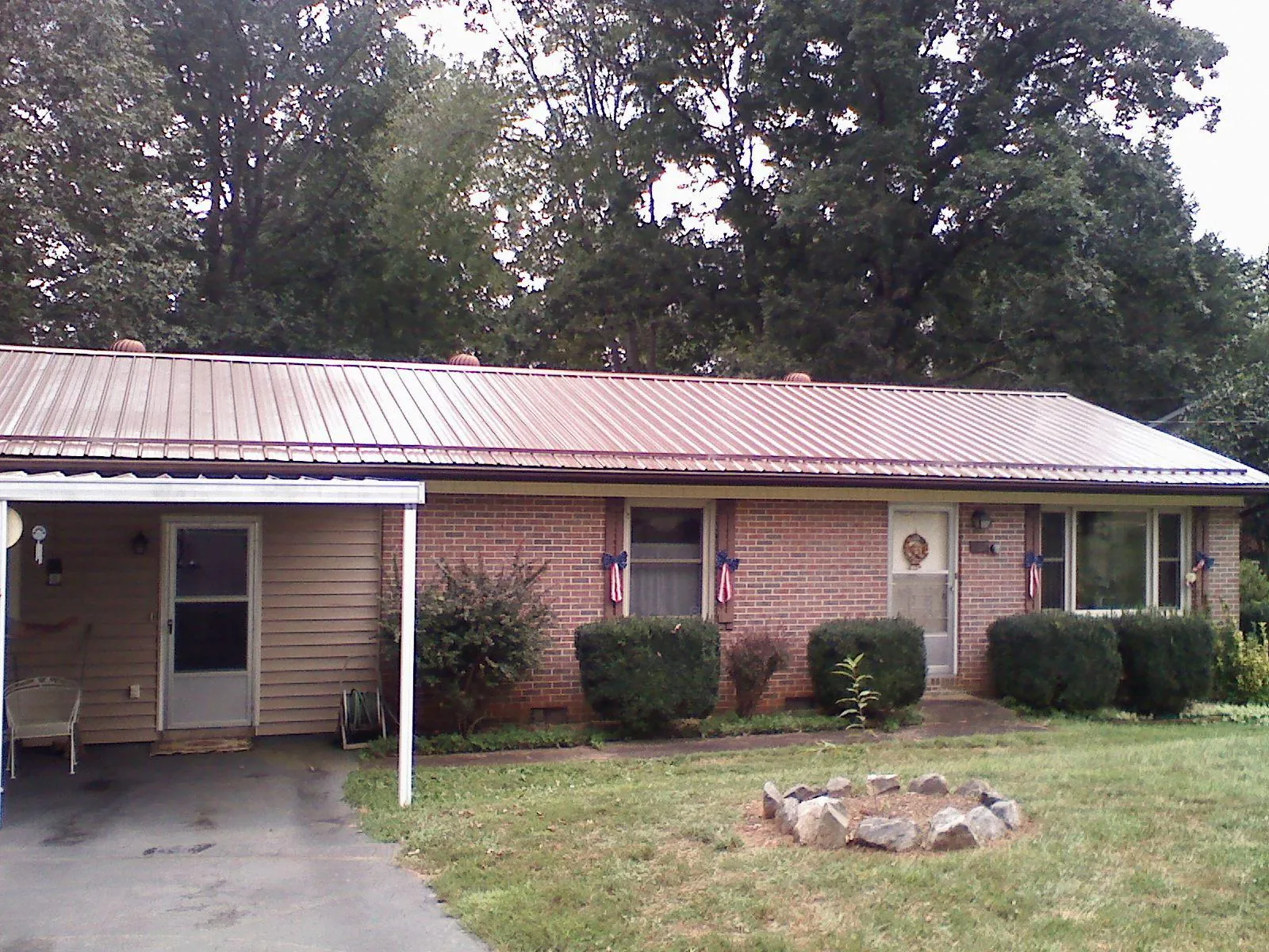 Bronze metal roof and carport on a brick ranch home — Roof Repair work by our crew in Flint Hill